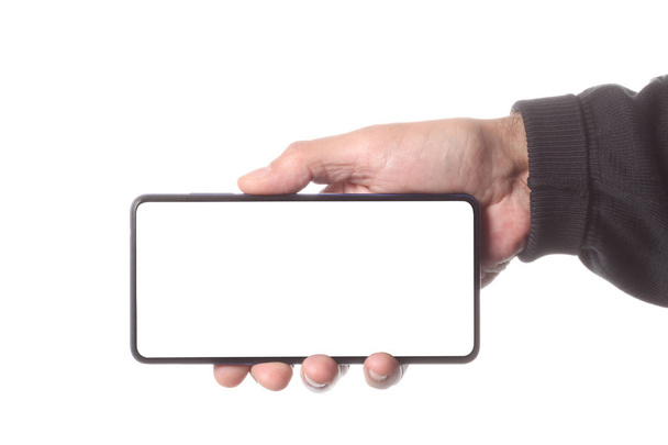 mężczyzna trzyma i pokazuje pusty inteligentny telefon na białym tle ze ścieżką przycinającą wokół dłoni i wyświetlacza z miejsca kopiowania dla tekstu - Zdjęcie, obraz