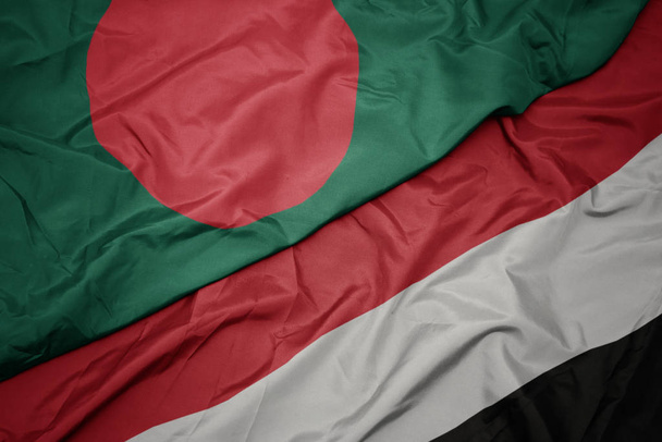 ondeando colorida bandera de yemen y bandera nacional de bangladesh
. - Foto, Imagen