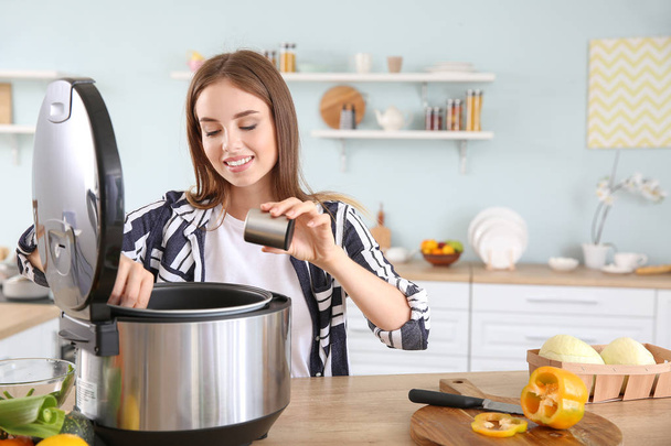 Woman using modern multi cooker in kitchen - Foto, imagen