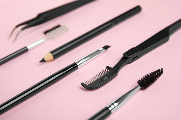 Set of professional eyebrow tools on pink background - Фото, изображение