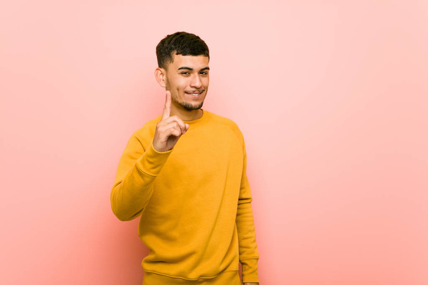 Young hispanic man showing number one with finger. - Foto, afbeelding