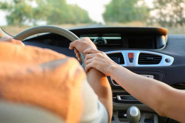 Happy woman holding hand of her boyfriend in new car - Photo, Image