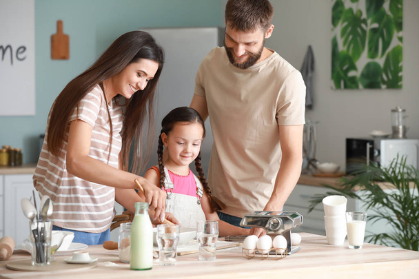 Молодая семья готовит вместе на кухне
 - Фото, изображение