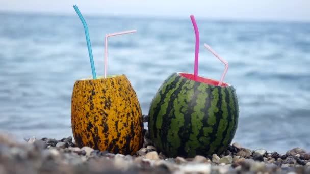 Дві жіночі руки беруть свіжі літні кавунові коктейлі з мармурового пляжу
 - Кадри, відео