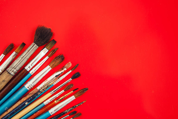 Set of paint brushes on the red background - 写真・画像