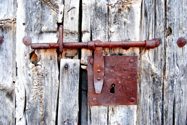 Régi ajtó rozsdás csavar, zár. Rozsdás, oxidálódik. Csuklópánt. Öreg faanyag. - Fotó, kép