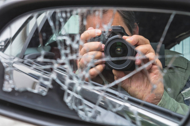 男は、Dslrカメラと写真撮影で車の中に座っています  - 写真・画像