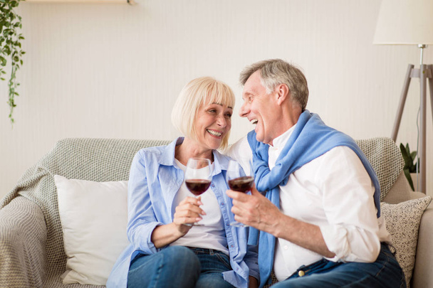 Αγαπώντας ώριμο ζευγάρι πίνοντας κόκκινο κρασί, γιορτάζοντας την επέτειο - Φωτογραφία, εικόνα