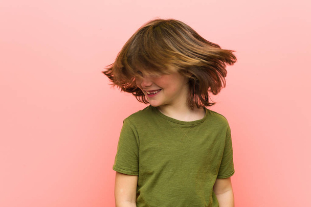 kleiner kaukasischer Junge spielt vor rosa Hintergrund - Foto, Bild