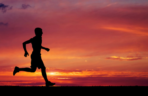 silueta běžící muž na slunce ohnivé pozadí - Fotografie, Obrázek
