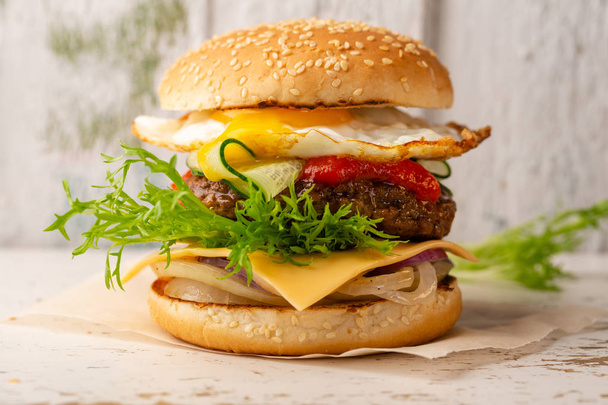 Gourmet burger with beef on white wooden background - Zdjęcie, obraz
