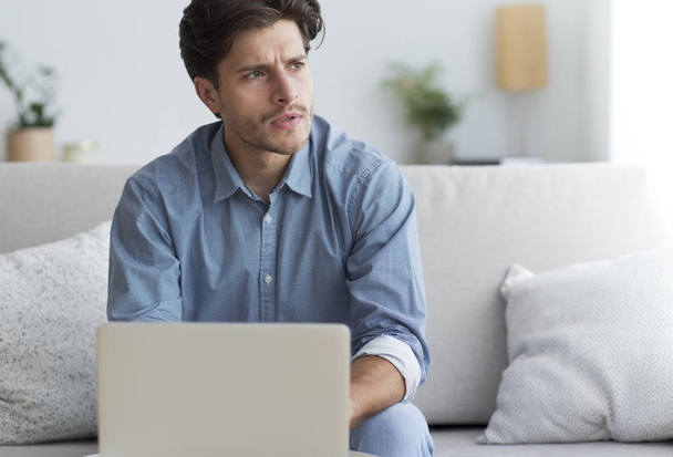 Pensive Entrepreneur At Laptop Thinking Sitting On Couch - Photo, Image