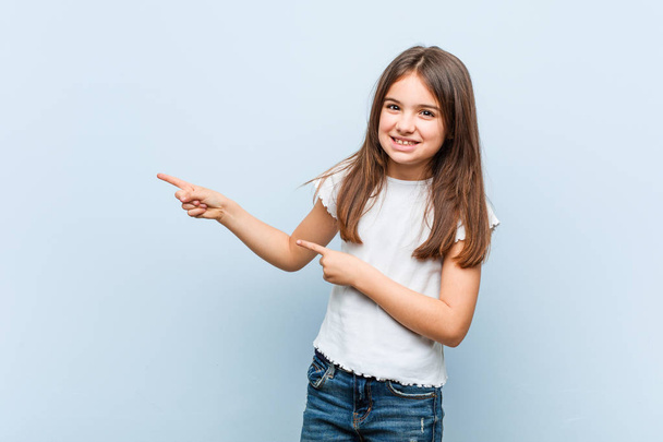 Cute girl excited pointing with forefingers away. - Foto, immagini