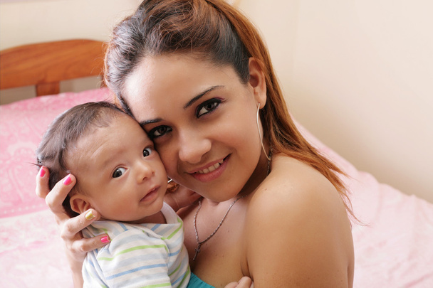 Портрет красивої іспаномовної щасливої матері зі усміхненою дитиною
 - Фото, зображення