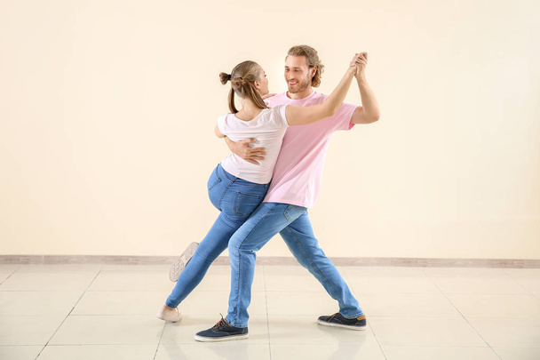 Cool jeune couple dansant contre le mur léger
 - Photo, image