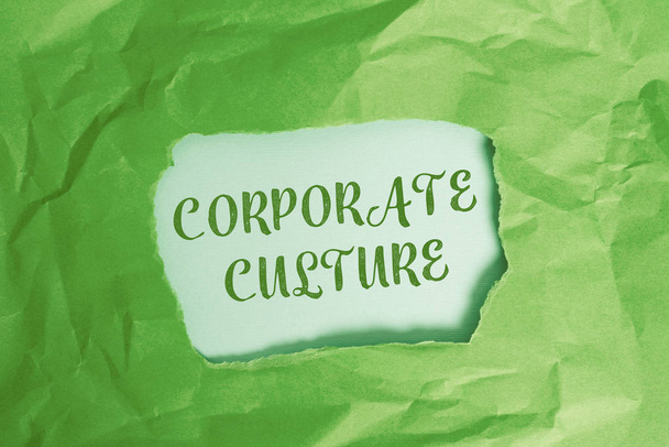 Text sign showing Corporate Culture. Conceptual photo pervasive values and attitudes that characterize a company Green crumpled ripped colored paper sheet centre torn colorful background. - Φωτογραφία, εικόνα