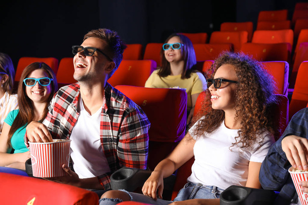 Friends with popcorn watching movie in cinema - Photo, Image