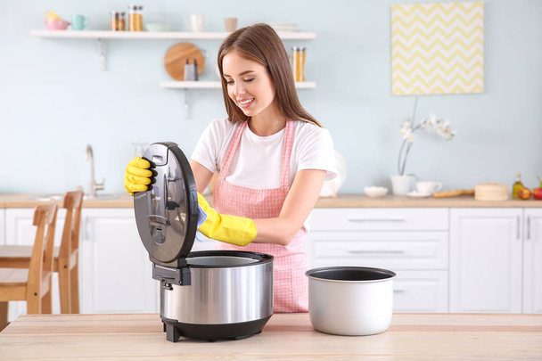 Femme de nettoyage moderne multi cuisinière dans la cuisine
 - Photo, image