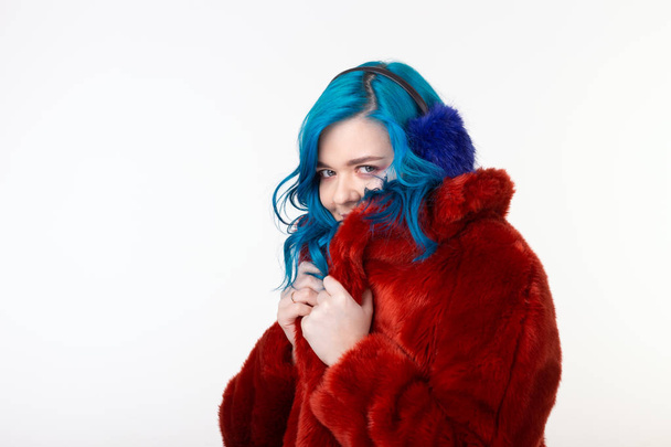 Animal protection, fashion and hair concept - beautiful girl wearing artificial fur coat with blue hair standing on white background - Φωτογραφία, εικόνα