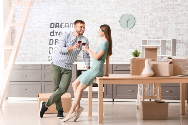 Onnellinen nuori pari juo viiniä muutettuaan uuteen taloon
 - Valokuva, kuva