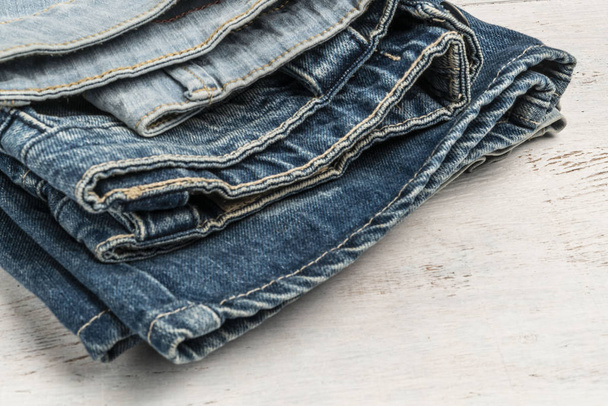 folded jeans on a wooden background with copy space - Photo, Image