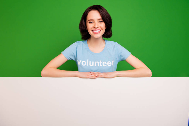 Portrait of her she nice attractive cheerful cheery glad content girl wearing blue t-shirt over copyspace advert ad vacancy hiring isolated over bright vivid shine vibrant green background - 写真・画像