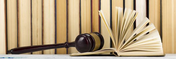 法律の概念 - 木製の裁判官が法廷や法執行機関のテーブルの上に与えたオープン法律書. - 写真・画像