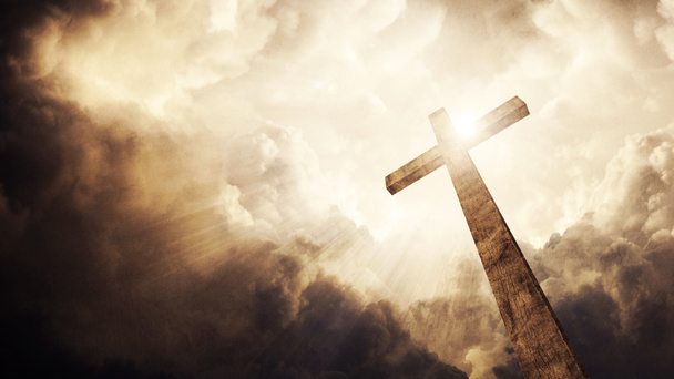 ένα ξύλινο Χριστιανικός Σταυρός με λαμπερό ήλιο και σύννεφα. - Φωτογραφία, εικόνα