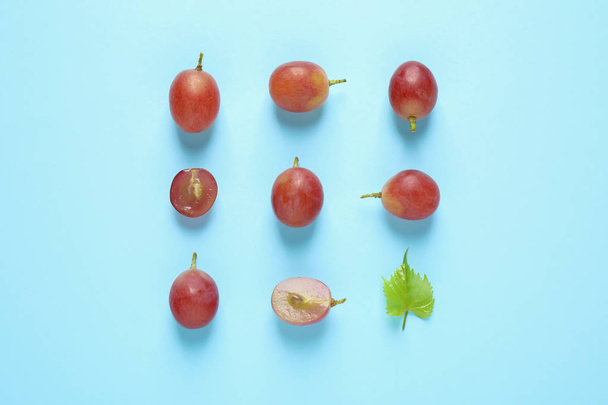 Flat lay composition with fresh ripe juicy grapes on light blue background - 写真・画像