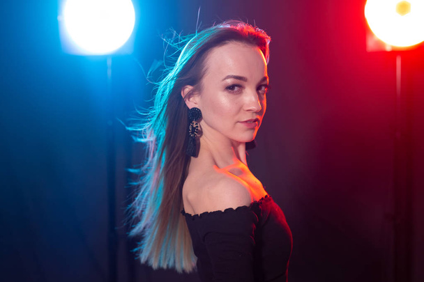 Nachtclub, Nachtleben und People-Konzept - junge Frau posiert im Dunkeln - Foto, Bild