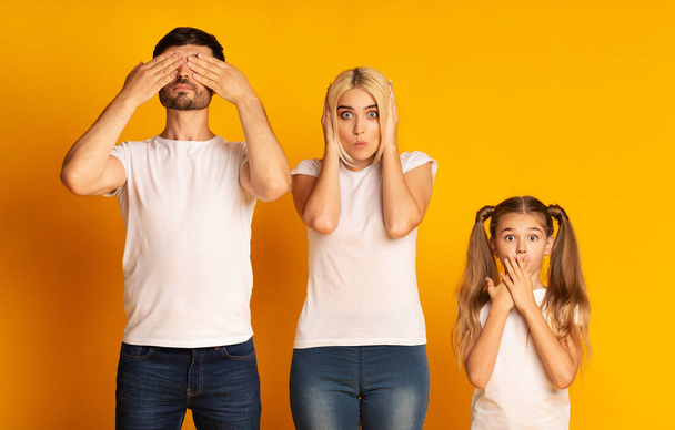 Family Covering Eyes, Ears And Mouth, Yellow Background In Studio - Foto, imagen