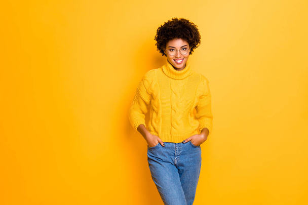 Photo of charming cute cheerful pretty beautiful girlfriend smiling toothily holding hands in pockets wearing jeans denim pullover isolated with vivid color yellow background - Foto, Imagem