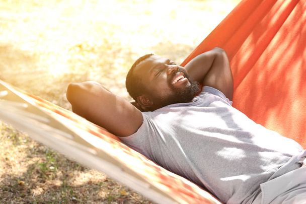 Афро-американський чоловік відпочиваючи в гамаку на відкритому повітрі - Фото, зображення