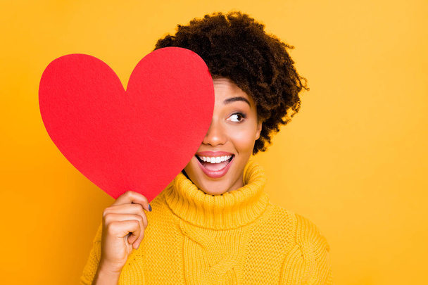 Photo of trendy cheerful cute nice charming curly fascinating girlfriend looking out away from red big heart wearing yellow jumper while isolated with bright color background - Foto, imagen