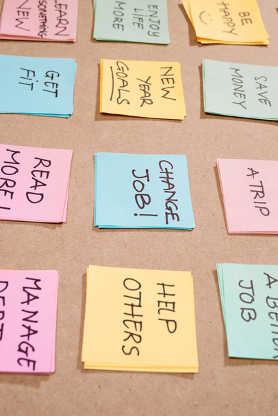 nouveaux objectifs ou résolutions de l'année - notes collantes colorées sur un bloc-notes avec tasse de café
. - Photo, image