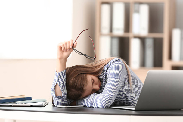 Mujer joven estresada en la mesa en la oficina - Foto, Imagen