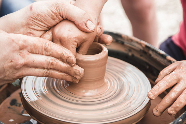 Una visione ravvicinata sul processo di produzione della ceramica sulla ruota del vasaio con i bambini. Artigianato in argilla con concetto bambini
. - Foto, immagini