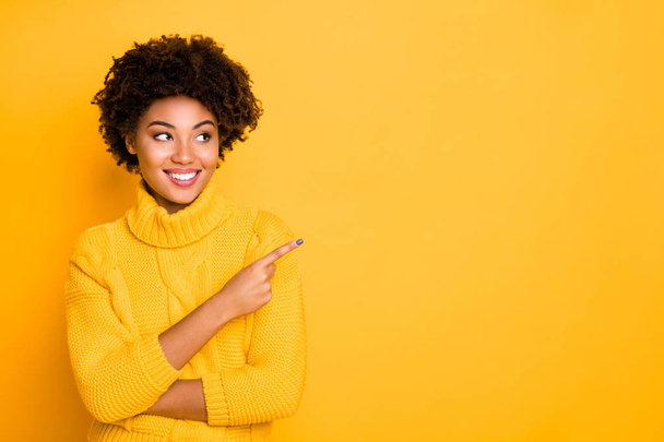 Photo of dark skin lady indicating finger empty space wear warm knitted pullover isolated yellow background - Fotografie, Obrázek