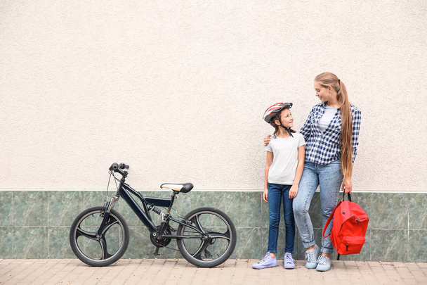 Жінка і її маленька дочка з велосипедом на відкритому повітрі
 - Фото, зображення