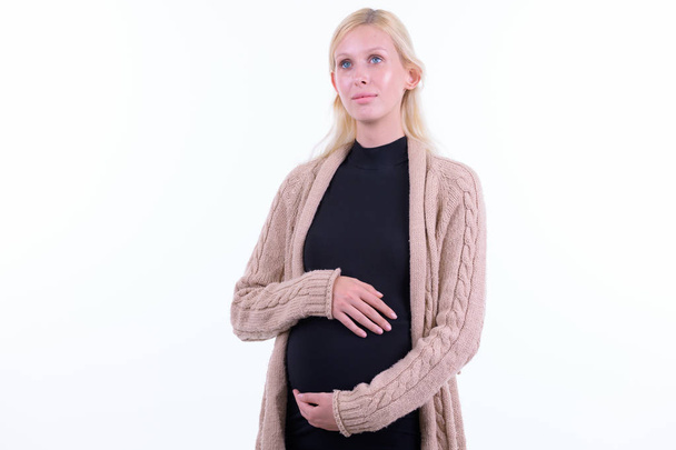 Young beautiful blonde pregnant woman thinking and looking up - Fotó, kép