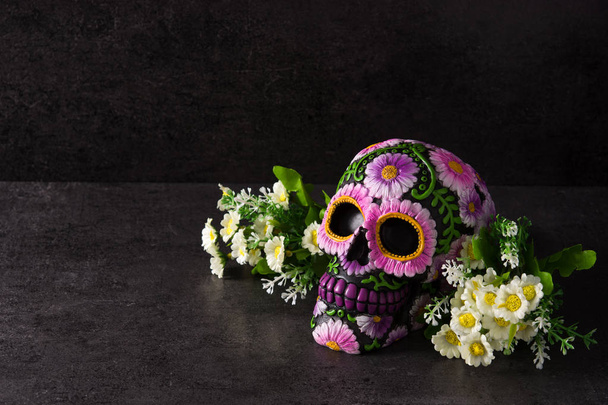 Typical Mexican skull with flowers painted on black background. Dia de los muertos. Copy space - 写真・画像
