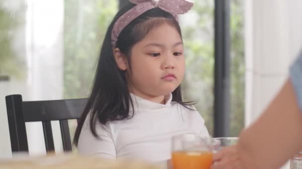 Ασιάτισσα Γιαπωνέζα κόρη βαριέται το φαγητό. Τα παιδιά του τρόπου ζωής λυπημένα αντιπαθούν το φαγητό αναστατώνουν το πρωινό γεύμα στην κουζίνα στο σπίτι το πρωί. Αργή κίνηση. - Πλάνα, βίντεο