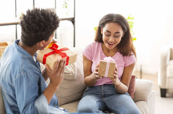 Heureux couple afro-américain échanger des cadeaux avec l'autre
 - Photo, image