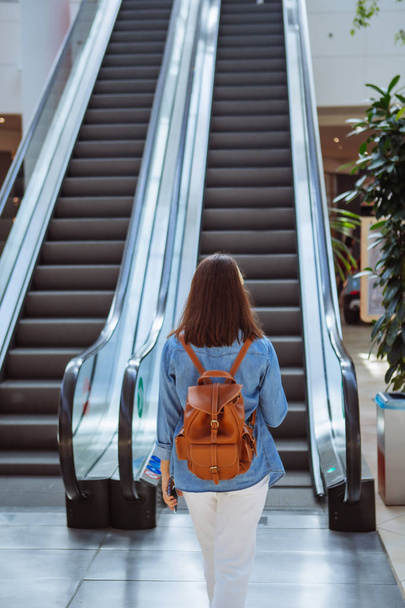 woman in city mall walking to escalator - Zdjęcie, obraz