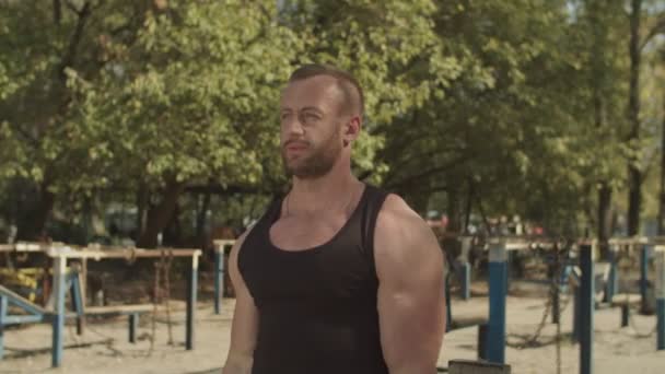 Strong bodybuilder performing barbell biceps curls - Metraje, vídeo