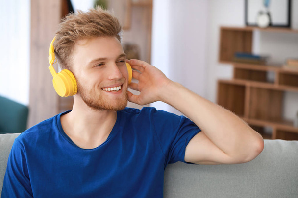 Красивий молодий чоловік слухає музику вдома
 - Фото, зображення