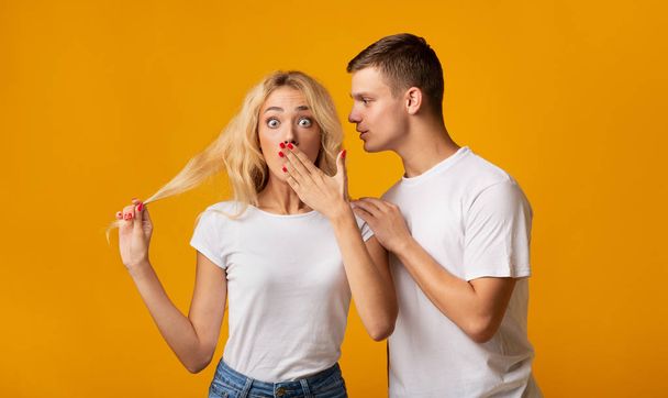 Guy whispering secret or gossip to surprised girl - Foto, Imagem