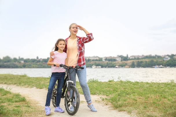 Женщина и ее маленькая дочь на велосипеде на открытом воздухе
 - Фото, изображение