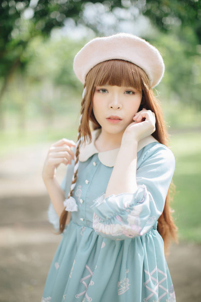 Portret van Aziatische meisje in Lolita Fashion jurk in tuin blauw - Foto, afbeelding
