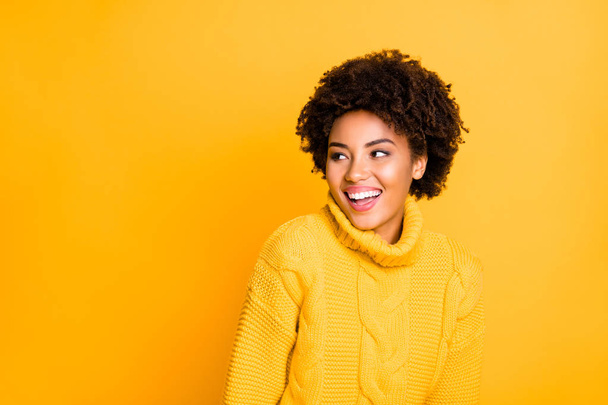 Photo of pretty dark skin lady looking with interest empty space wear warm knitted jumper isolated yellow background - Fotografie, Obrázek